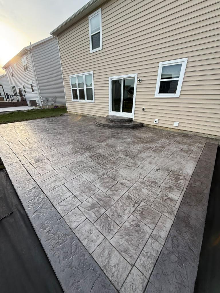 Freshly finished concrete patio poured and troweled alongside a residential home